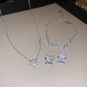 Detailed view of silver star jewelry set with necklace bracelet and sparkling earrings