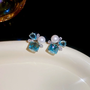 Detailed macro of square blue crystal earrings with pearls and zircon in luxury design