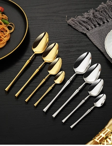Polished 304 stainless steel spoons in gold and silver finish on a dark wooden table