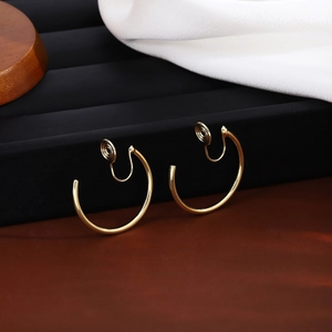 Detailed macro view of golden metal hoop earrings with spiral clip-on backs for non-pierced ears