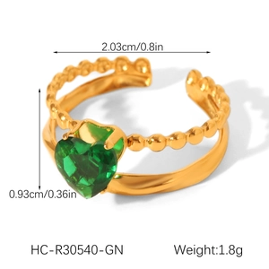 Detail view of gold heart ring with green zircon inlay and beaded texture band