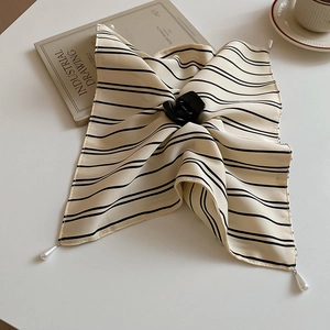 Détail du foulard rayé avec pendentifs perles et une pince à cheveux noire élégante
