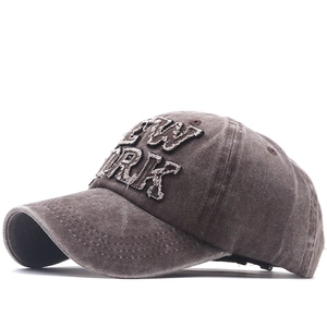 Detail of New York 3D embroidery with distressed fringe edges on brown washed canvas cap
