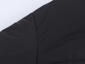 Détail de la couture d'épaule et du tissu synthétique mat de la doudoune courte noire