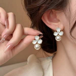 Elegant three-petal flower earrings with white enamel petals, crystal core, and hanging pearls