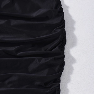Detailed macro view of black fabric with gathered pleats and a subtle glossy finish