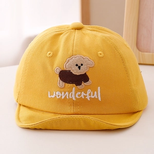 Détail d'une casquette jaune pour bébé avec broderie chien et inscription wonderful