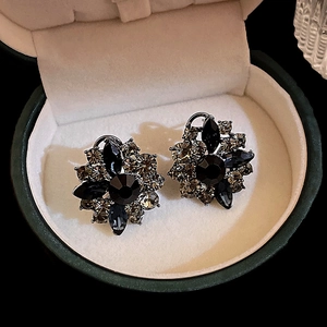 Macro shot of luxury floral earrings featuring black crystals and smokey gray rhinestones
