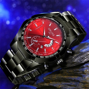 Macro shot of large red dial chronograph watch with black steel band on stone