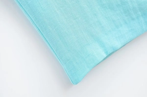 Gros plan sur les coutures et la texture en coton-lin de la robe midi bleu clair
