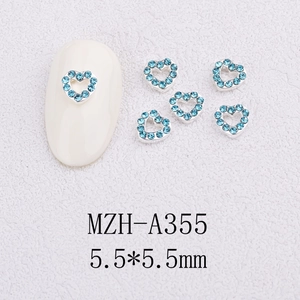 Close-up of heart-shaped 5.5mm nail charms with blue rhinestones and silver metal base