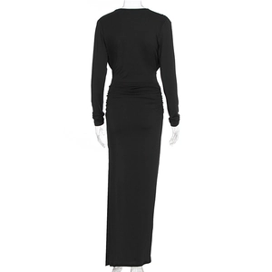 Detail of elegant black long sleeve maxi dress featuring gathered waist and ruched fabric texture