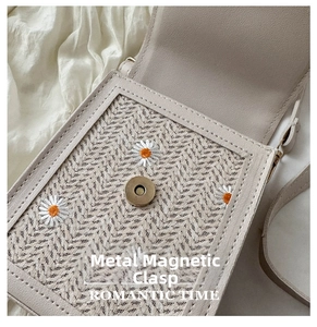 Close-up of lace woven crossbody bag with daisy embroidery and magnetic snap closure