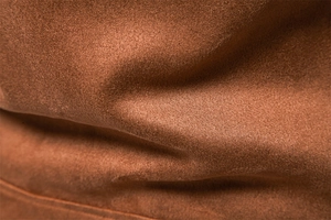 Macro shot of high-quality brown faux suede fabric showing soft texture and fine grain