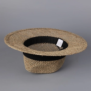 Detail view of the breathable straw weave texture and interior sweatband with 100% grass label