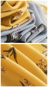 Macro shot of twill silk fabric showing detailed floral prints in yellow and grey blue