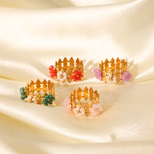 Vue détaillée de bagues couronne vintage dorées avec fleurs perlées sur fond de soie