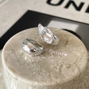 Close-up of 925 silver U-shaped star earrings with zircons on marble display