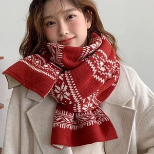 Close-up of red and white knit scarf with winter snowflake patterns and geometric motifs