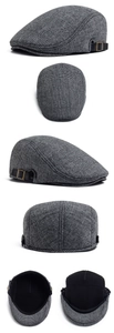 Detail view of grey plaid wool beret with ear flaps and leather strap buckle