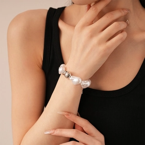 Vue détaillée du bracelet en perles baroques et bille d'argent sur le poignet