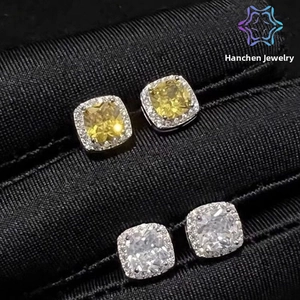 Macro shot of silver halo stud earrings with square-cut yellow and clear zircon stones