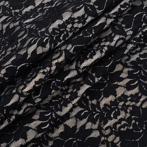 Gros plan sur le tissu en dentelle noire aux motifs floraux et texture mesh délicate