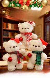 Dettaglio di tre orsetti di peluche bianchi con cappelli rossi e sciarpe natalizie