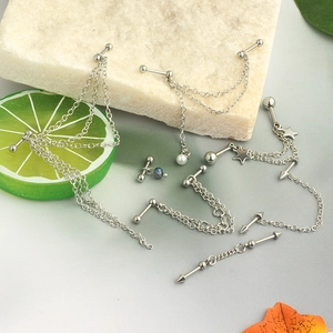 Star-shaped industrial ear piercing chain with faux pearls and silver pendants on marble