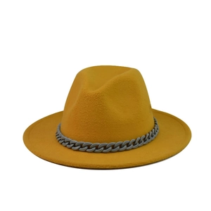 Detailed texture of yellow wool fedora hat with a modern grey chain decoration