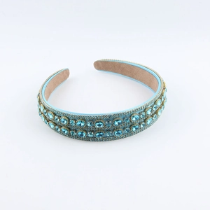 Elegant Baroque headband with double-row blue crystals on a golden frame over white background