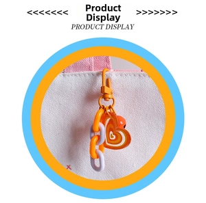 Detail of creative double heart pendant with orange chain on a white canvas bag