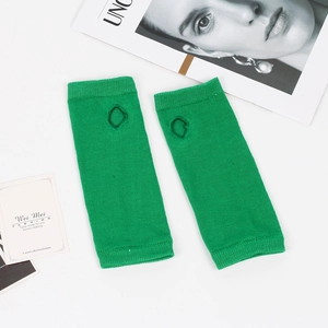 Detailed close-up of neon green knitted fingerless arm warmers with thumb hole design