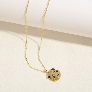 Detailed macro view of the sparkling white zircon paved panda pendant on a gold chain