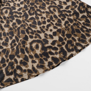 Close-up of leopard print fabric detail and double-needle stitching on dress hem