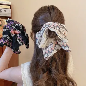 Chouchous tricotés à motif ondulé style ethnique en noir et beige sur queue de cheval