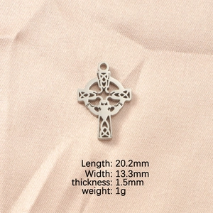 Detail view of silver Celtic knot pendant showing dimensions 20.2mm by 13.3mm on beige fabric
