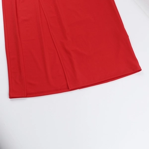 Détail de l'ourlet de robe rouge montrant la double couture et la texture du tissu textile