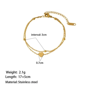 Double-layered gold stainless steel bracelet with beads and heart pendant on white background