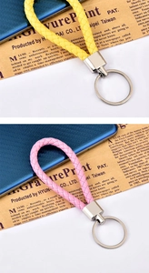 Dettaglio di portachiavi in pelle intrecciata rosa e gialla con anello in metallo argento