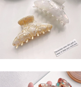Close-up of marble acetate hair claw clips showing premium glossy finish and patterns