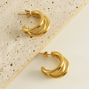 Irregular triple-layered C-shaped 18K gold plated earrings on a natural stone base