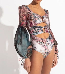 Detail of vintage floral bodysuit with waist cut-outs, metal rings, and lantern sleeves