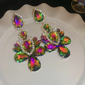Macro shot of colorful teardrop earrings with crystals on a ceramic display