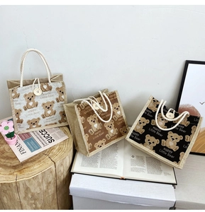 Detail of cute bear printed jute lunch bags with cotton rope handles and button decor