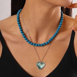 Double-layered beaded necklace with blue resin beads and a heart-shaped glass pendant