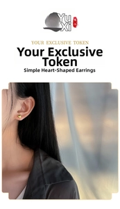 Detailed view of polished 18K gold heart studs worn by a model for a minimalist look