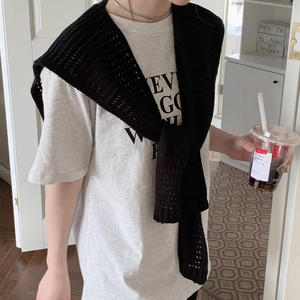Detail of a chic black knitted shawl elegantly draped over shoulders for a stylish look