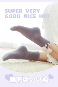 Detail of plush purple mink velvet socks featuring white pompoms and ribbon bow decoration