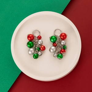 Detail of Christmas earrings with colorful red, green and silver beads on a tray